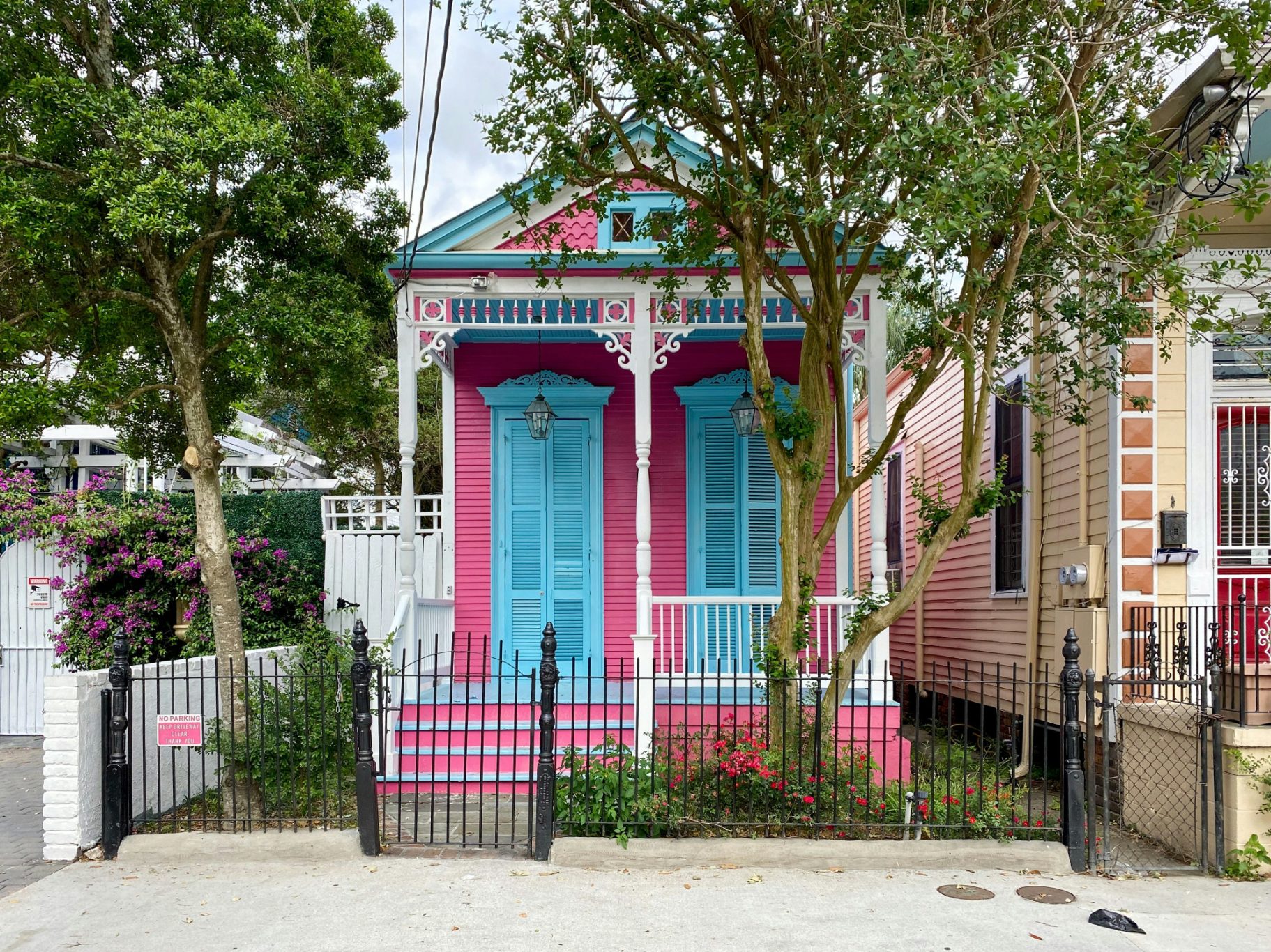 A pink and blue house with a black fence in New Orleans, Louisiana